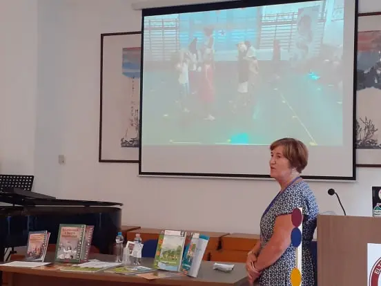 A könyvek előtt projektorral van bemutatva a foglalkozás egy videón keresztül